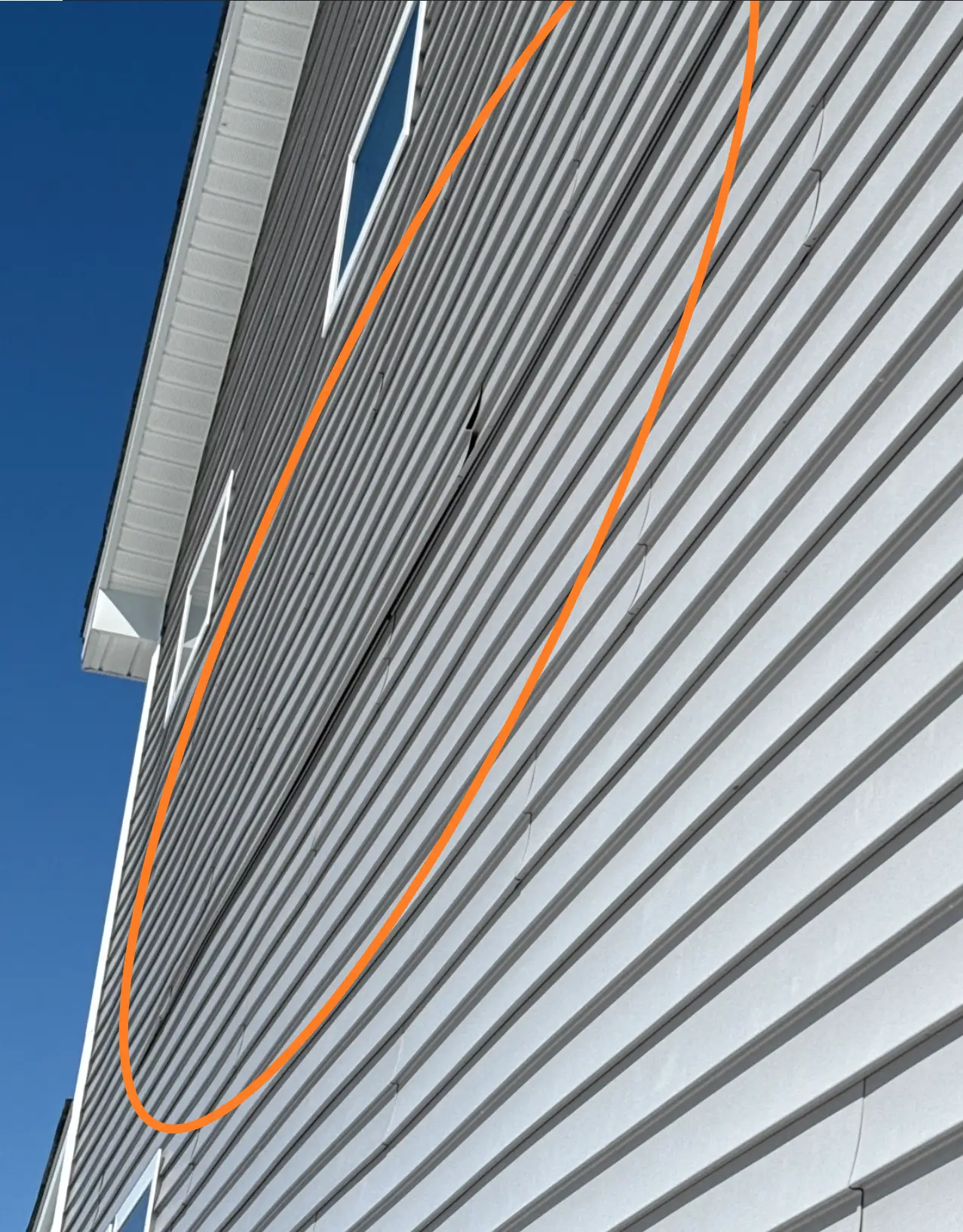 Loose exterior siding panel separating from wall surface
