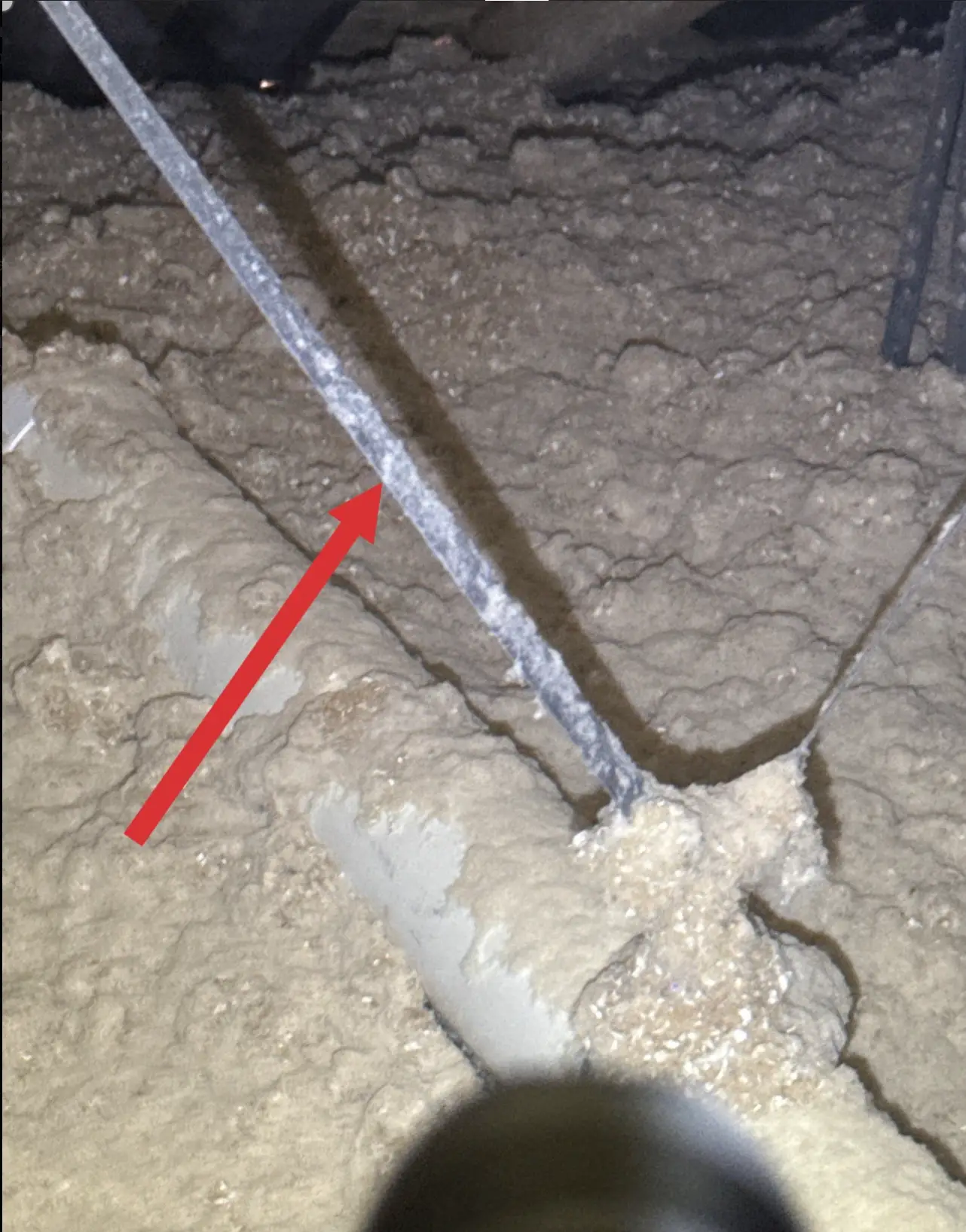 PVC vent pipe supported with perforated metal strap in attic